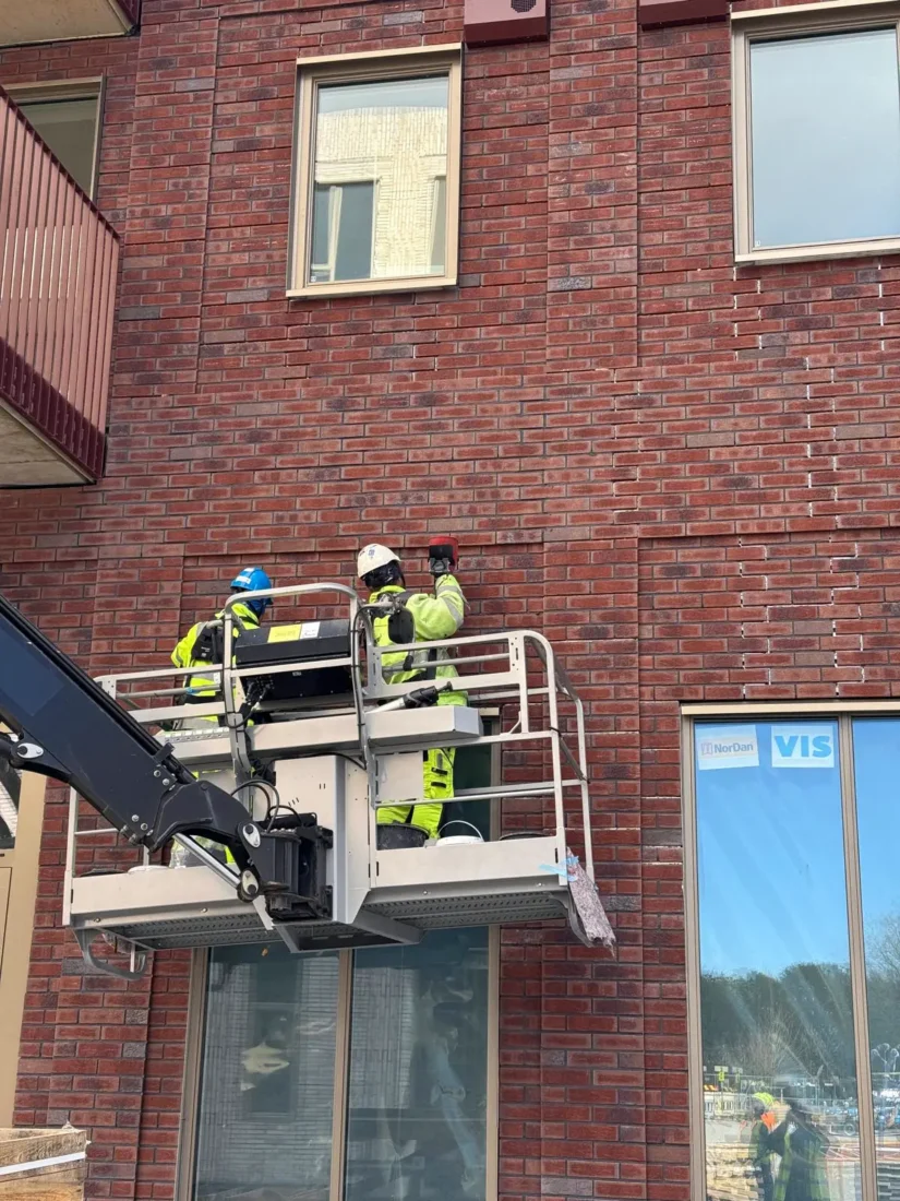 ansatte som fuger stofix paneler via lift